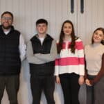 employer and apprentices standing in front of a white wall