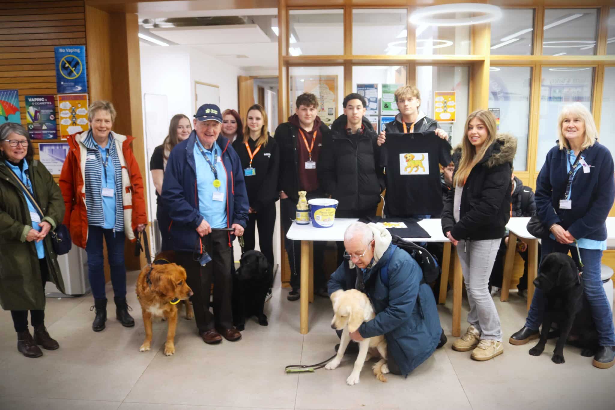 students staff and guide dogs surrounding table
