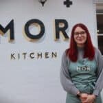 woman standing in front of white wall with black letters