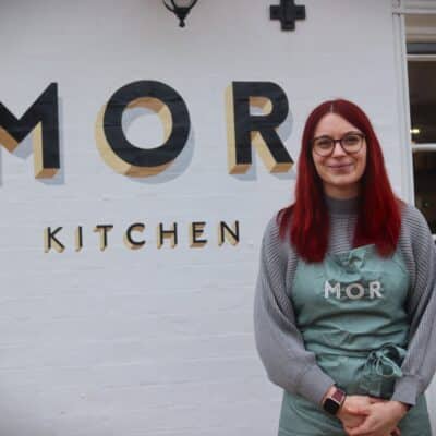 woman standing in front of white wall with black letters