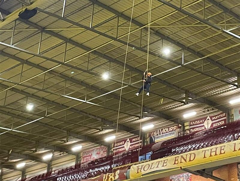 students abseiling in stadium