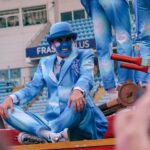 dancer in blue sat down on float