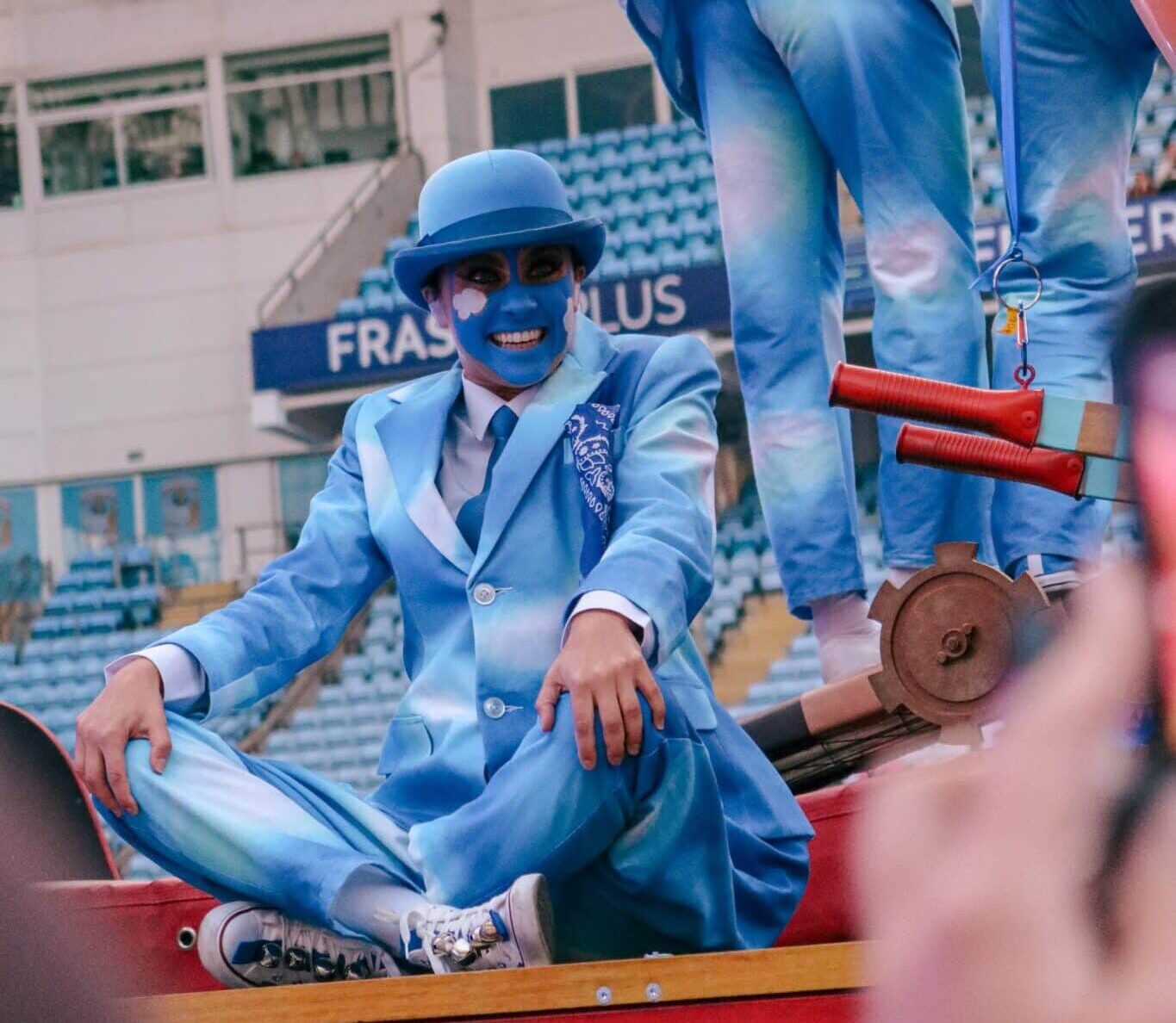 dancer in blue sat down on float
