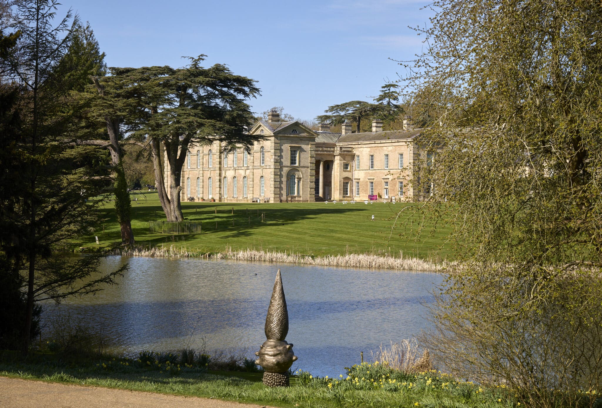 landscape - a lake in the foreground and large house in the background