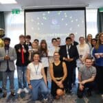 students and staff in front of a screen