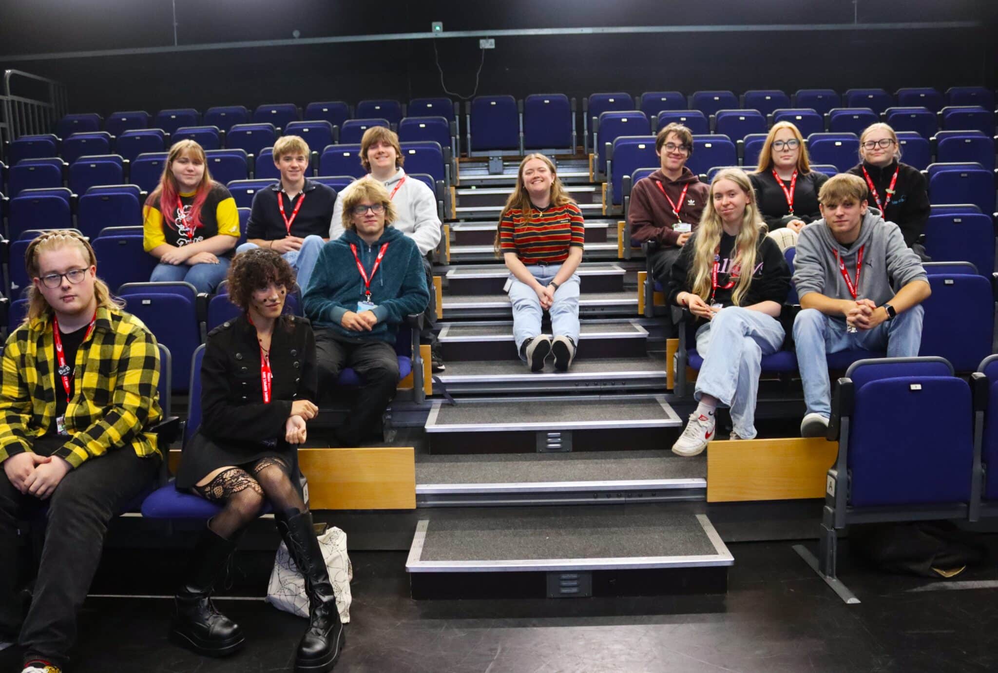 person sat on stairs with students sat on seats either side